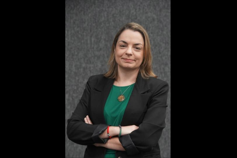 A juíza Gabriela é uma mulher de cerca de 45 anos. Tem e pele clara e cabelos castanhos e lisos, pela altura do ombro. Veste um  blaser preto e blusa verde.