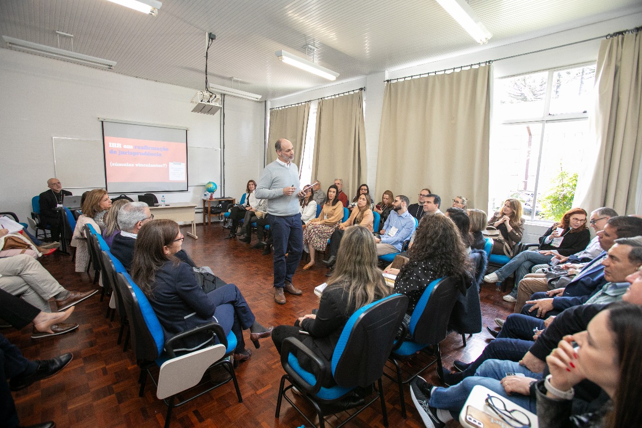 A foto mostra o servidor gustavo ministrando aula para magistrados.