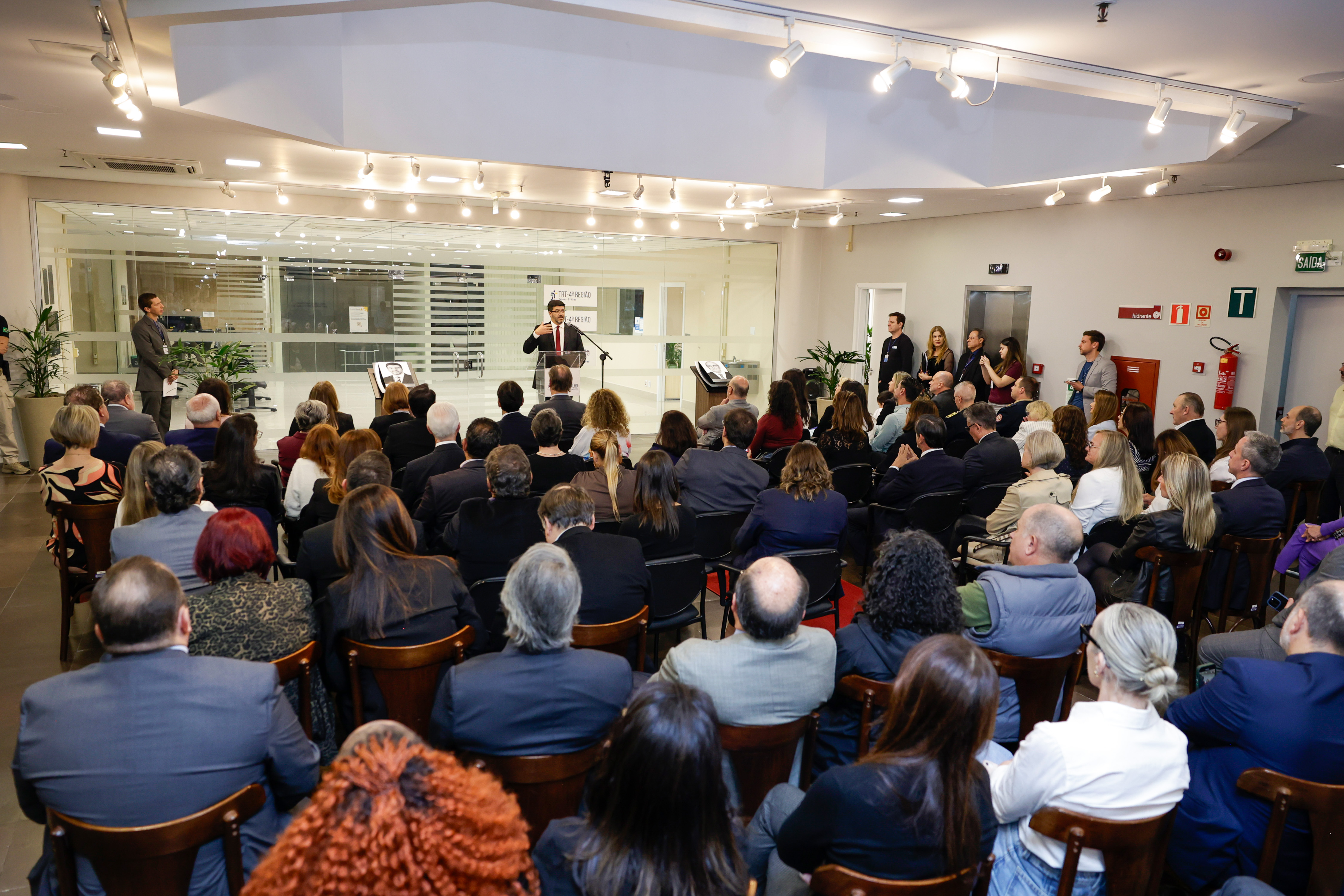 Foto em ângulo aberto, mostrando público de costas