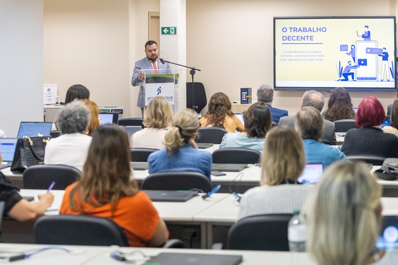 foto em ângulo aberto, com público de costas e Danilo falando ao fundo