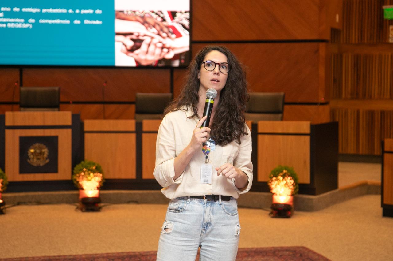 A foto mostra a servidora Bruna Lunardi – Secretaria de Gestão de Pessoas - falando ao microfone.