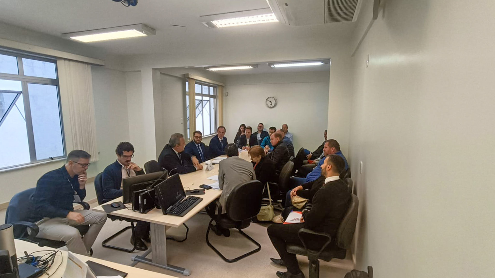 A foto mostra uma mesa com diversas pessoas em volta.