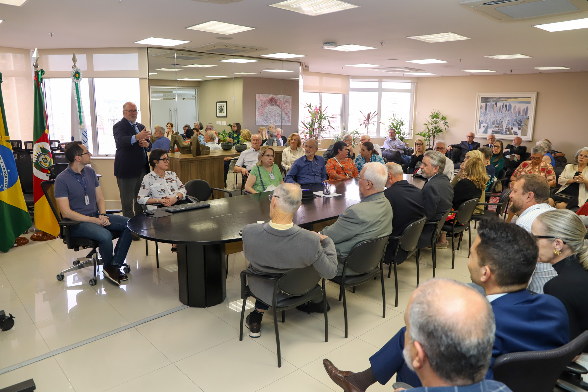 A foto mostra a mesa de reunião com os participantes.