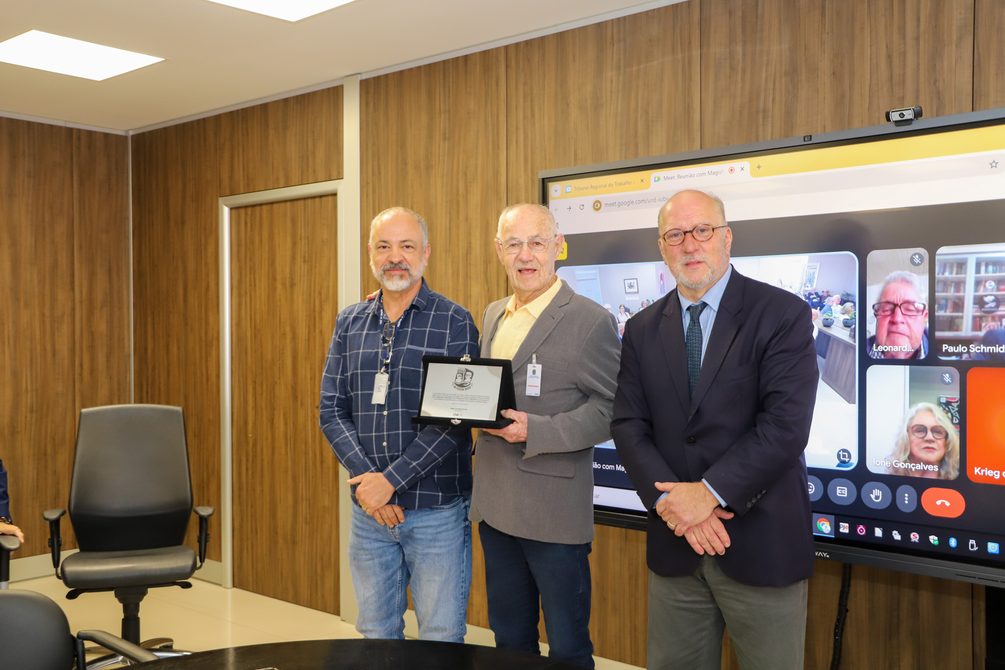 A foto mostra a mesa de reunião com os participantes.