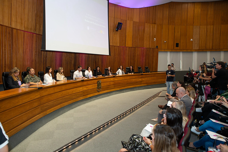 A foto mostra a mesa de autoridades com a juíza Lúcia Mattos.