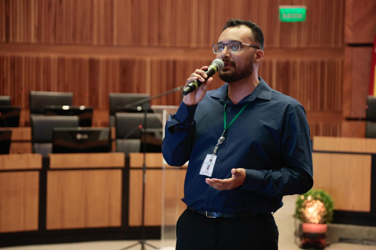 A foto mostra o servidor Cícero falando ao microfone.