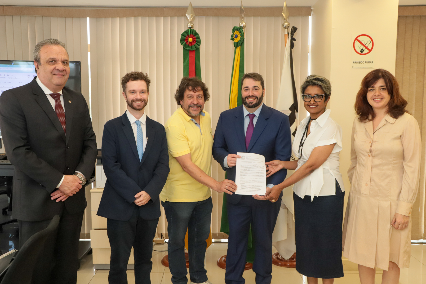 A foto mostra reunião em volta de uma mesa.
