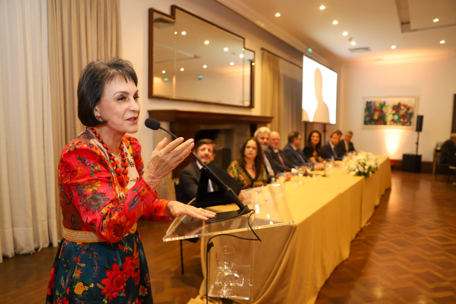 Foto da ministra discursando.