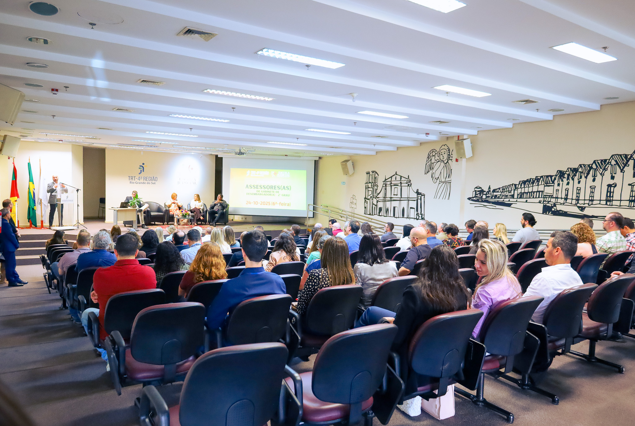 Foto em ângulo aberto, mostrando público em primeiro plano e o palco.
