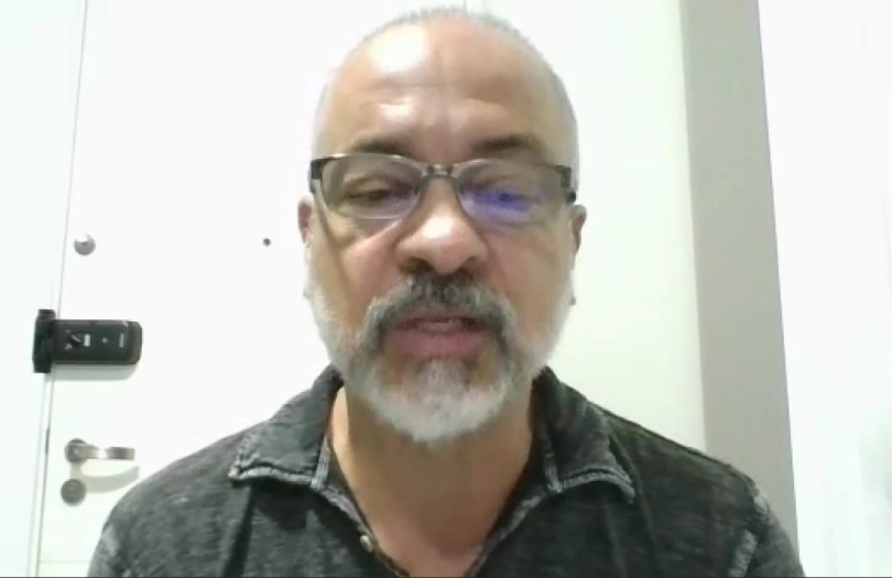 Márcio é um homem negro, de 62 anos. Ele é magro e tem barba e poucos cabelos brancos. Usa camiseta cinza.