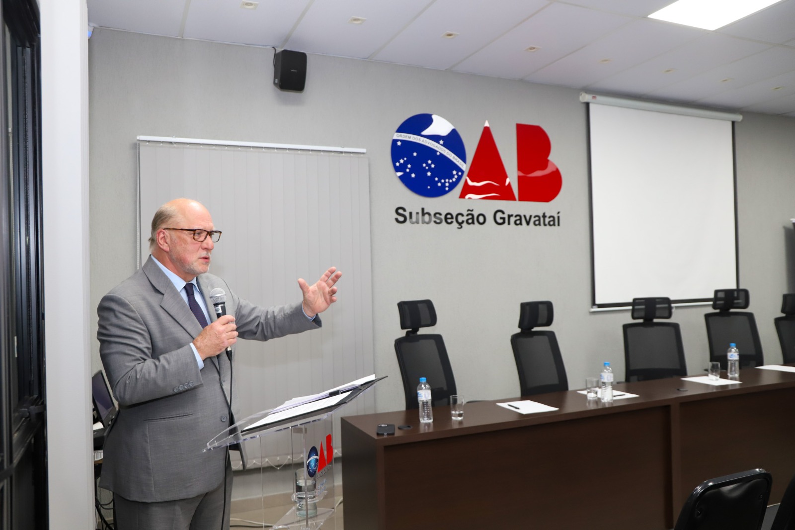 A foto mostra Martins Costa com logo grande da oab de fundo.