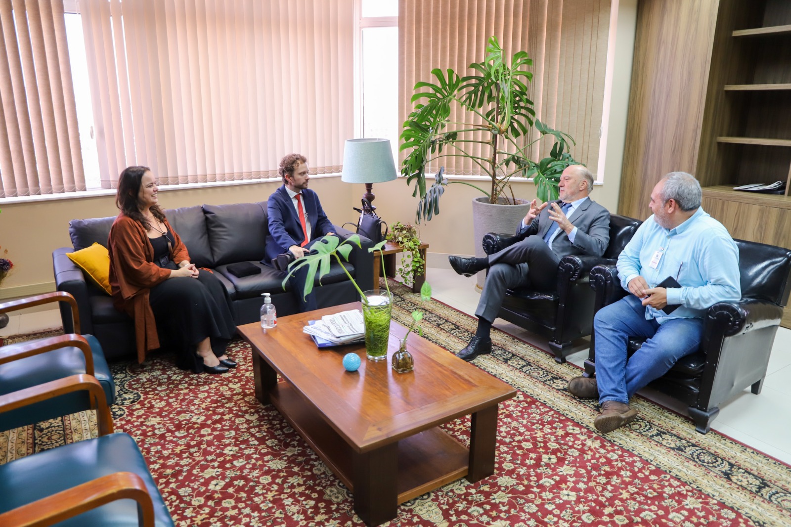 A foto mostra reunião de pessoas sentadas em poltronas.