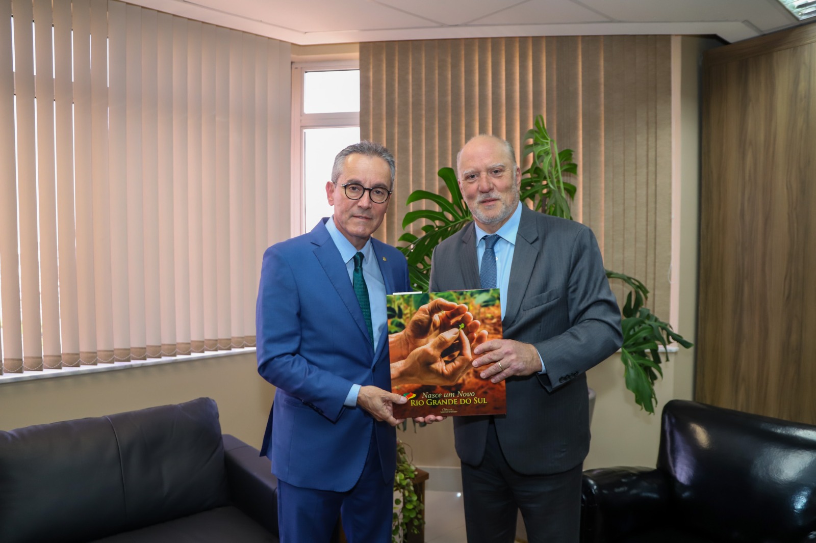 Foto de martins costa entregando livro para amilcar.