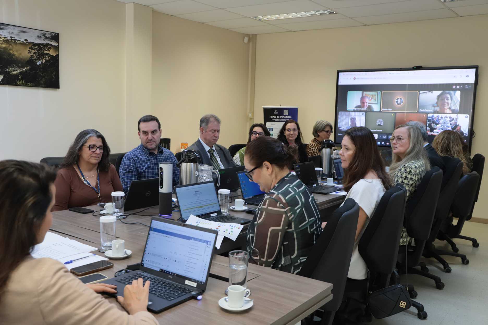 Fotografia de todos os participantes da reunião sentados em uma mesa.