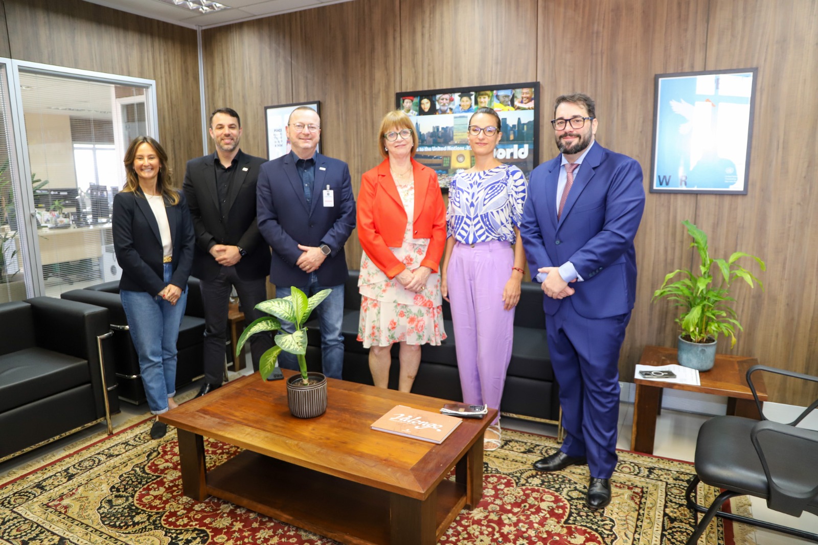 A foto mostra os presentes na reunião posando para foto.