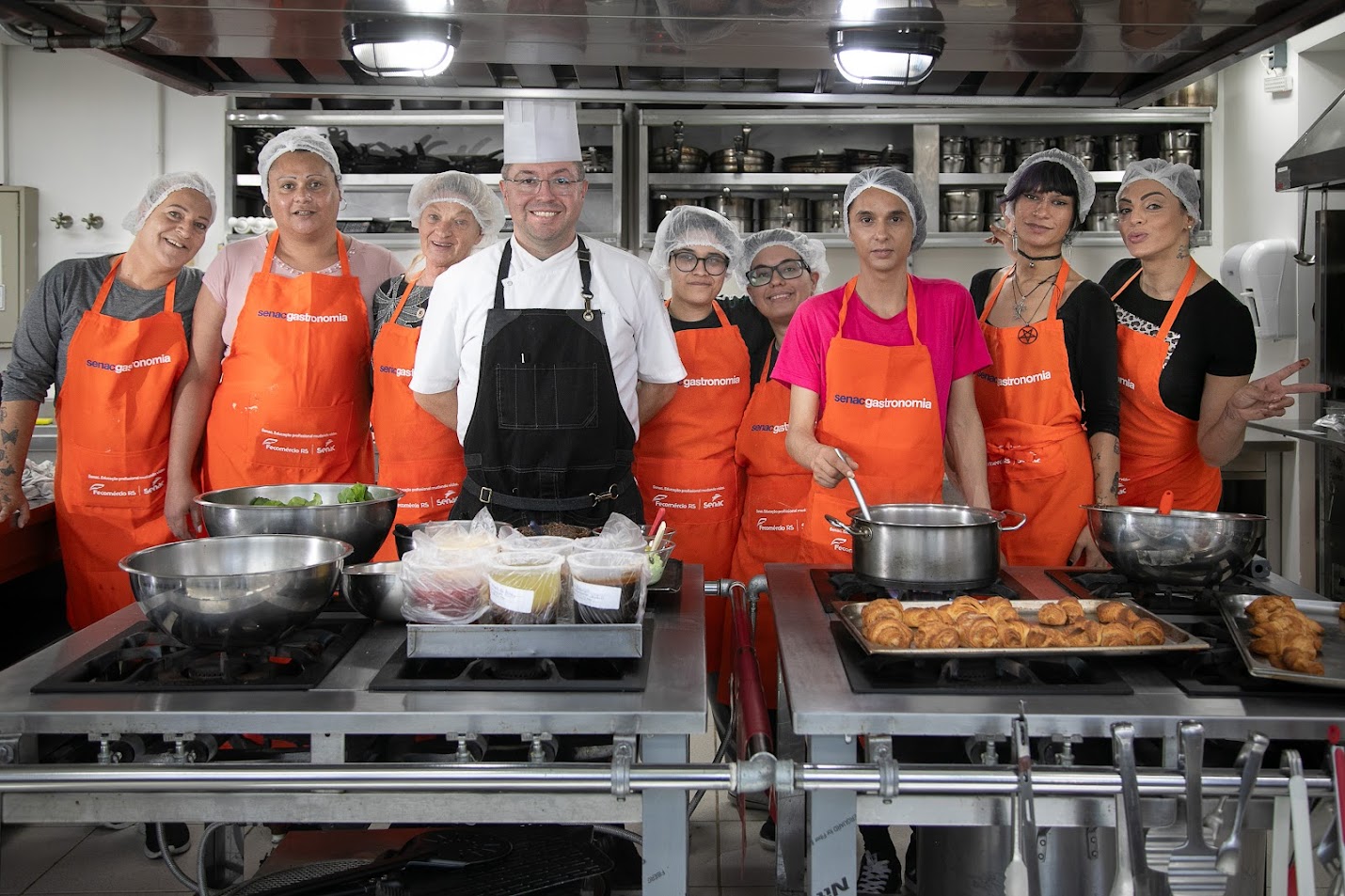 Foto da turma do curso, com o professor, na cozinha industrial do Senac.