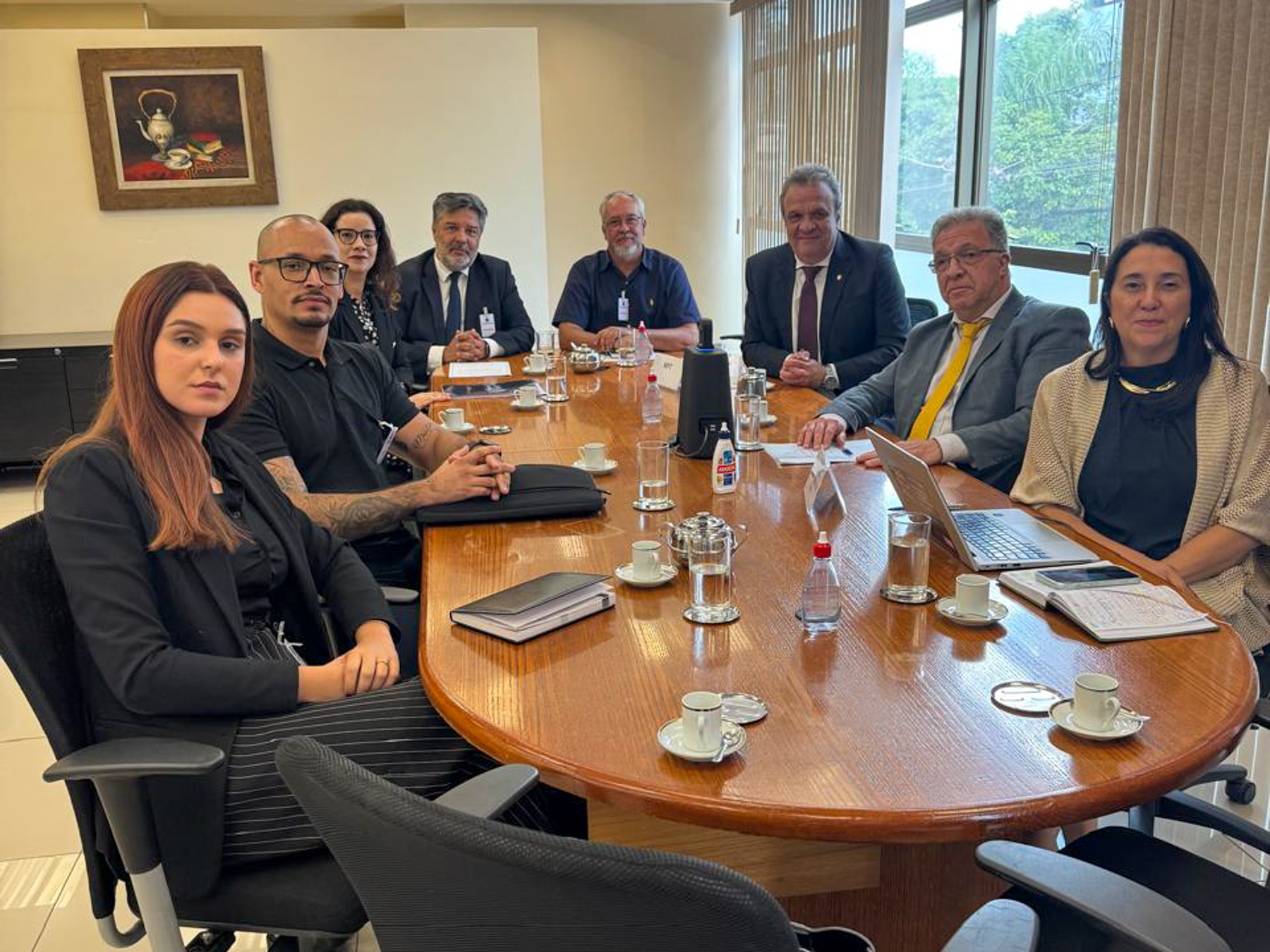 Foto dos participantes da mediação, sentados à mesa redonda.