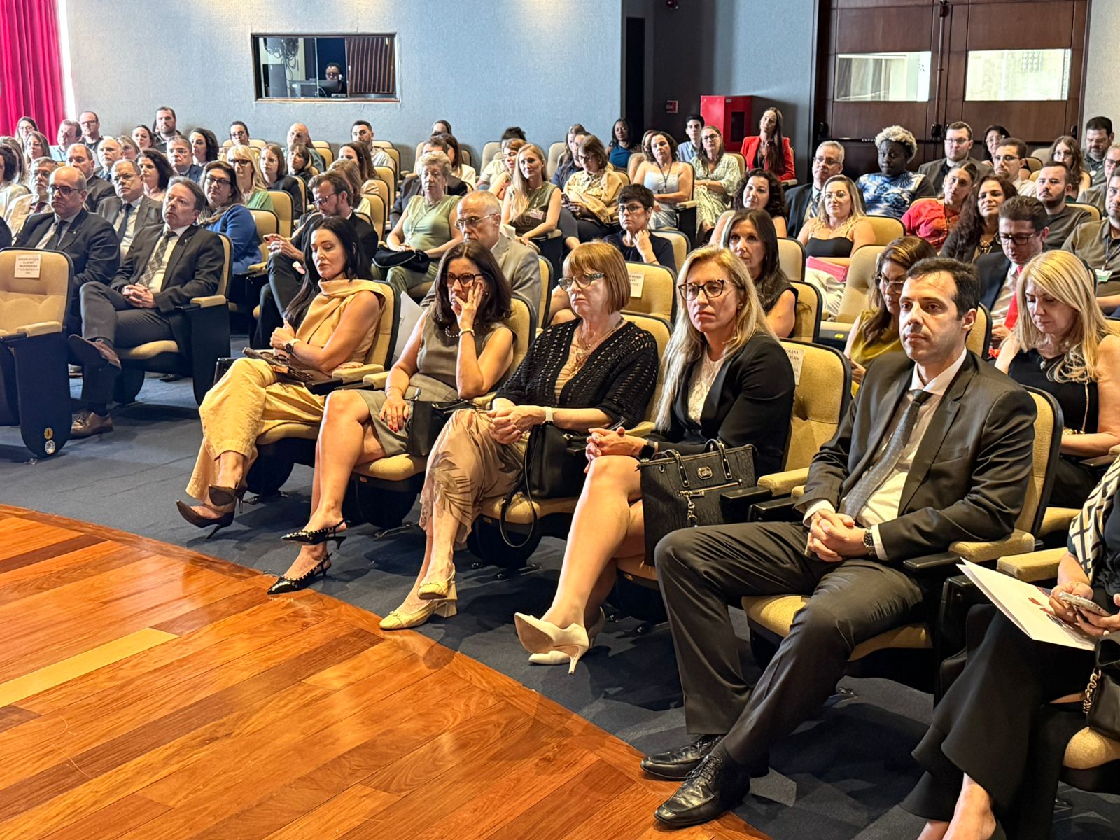 A foto mostra pessoas numa plateia.