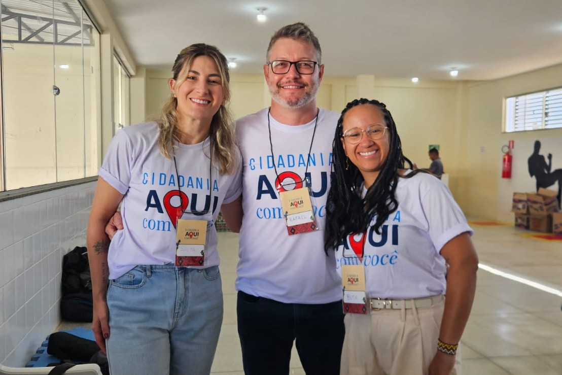 A foto mostra três pessoas posando para foto.
