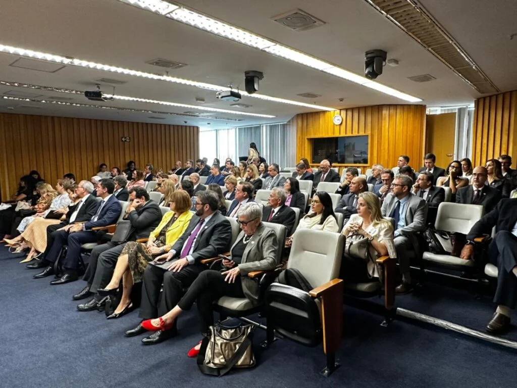 Diversas pessoas na plateia de um auditório