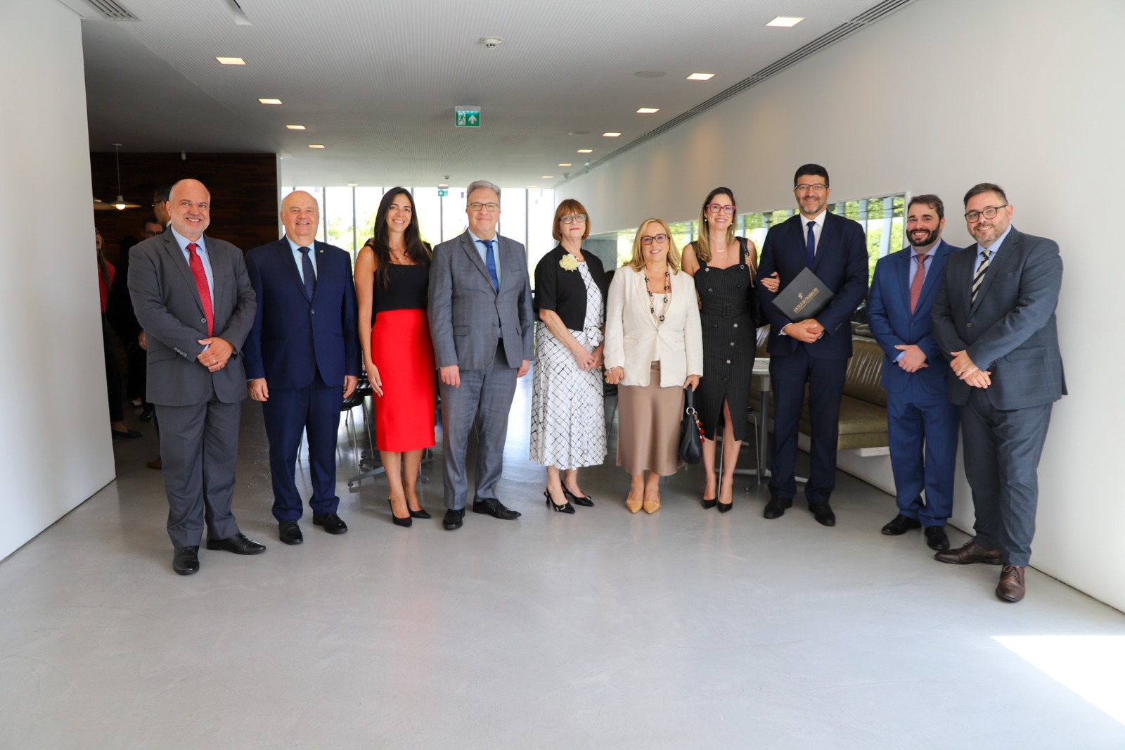 A foto mostra uma série de pessoas lado a lado posando para foto.