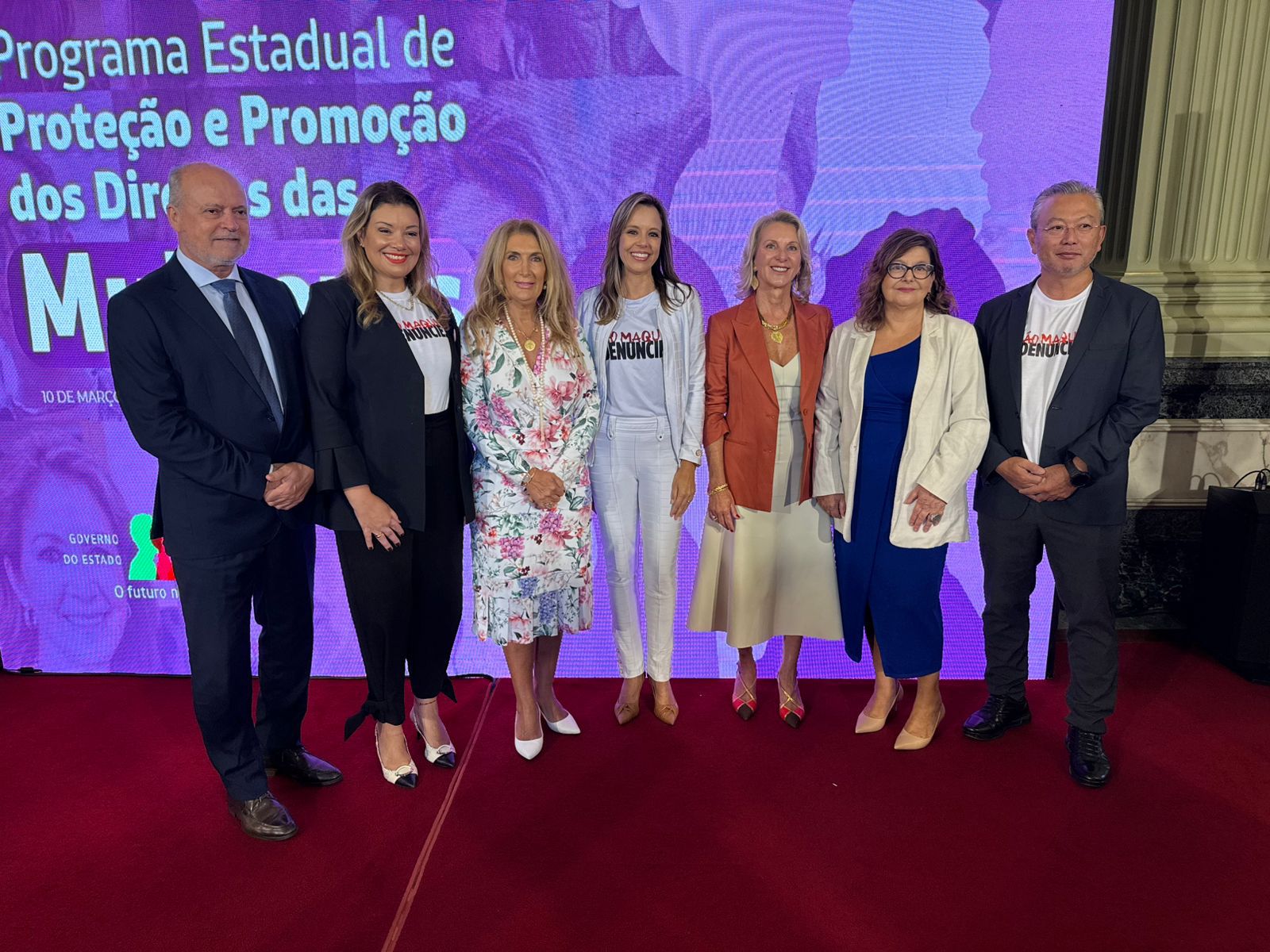 A foto mostra a desembargadora Carmen, no salão do Palácio Piratini, posando para foto com outras seis pessoas.