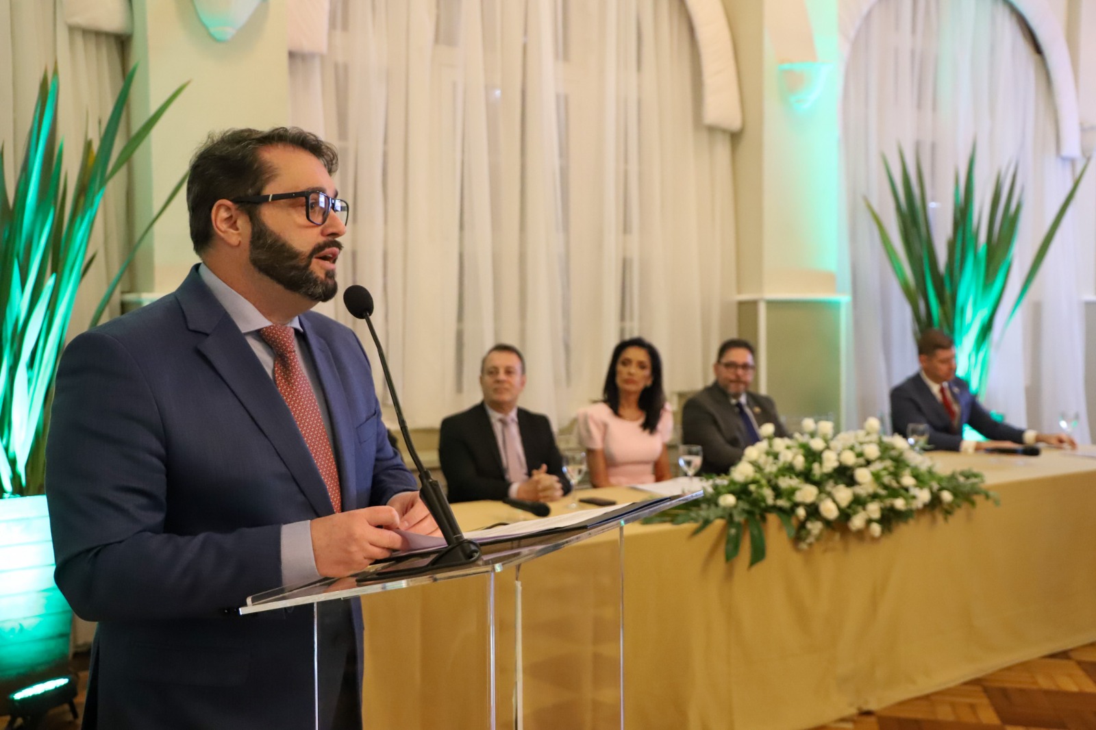 A foto mostra o presidente Alexandre discursando.