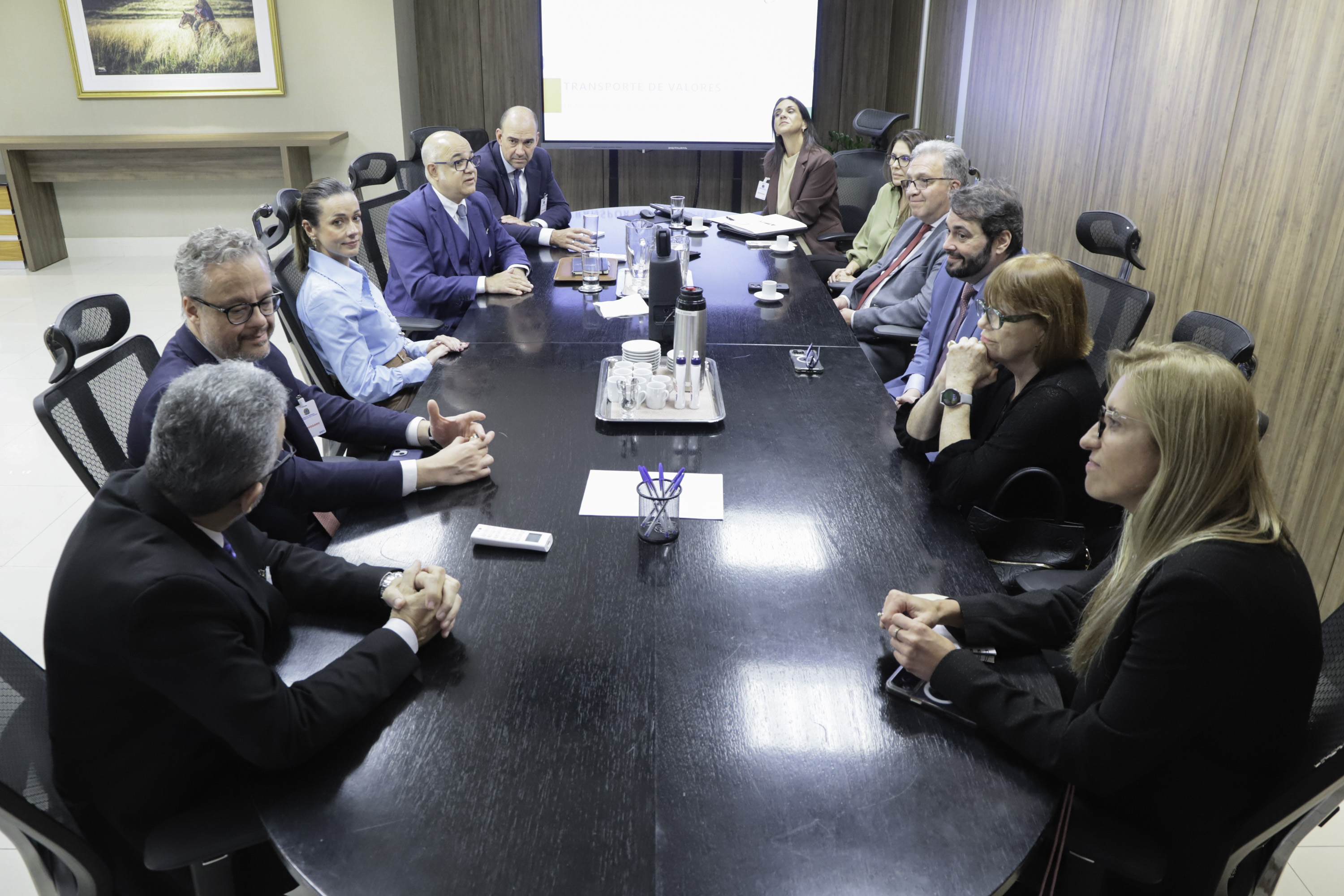 Grupo de pessoas em reunião no Salão Nobre. O clima é formal, com alguns participantes gesticulando enquanto conversam.