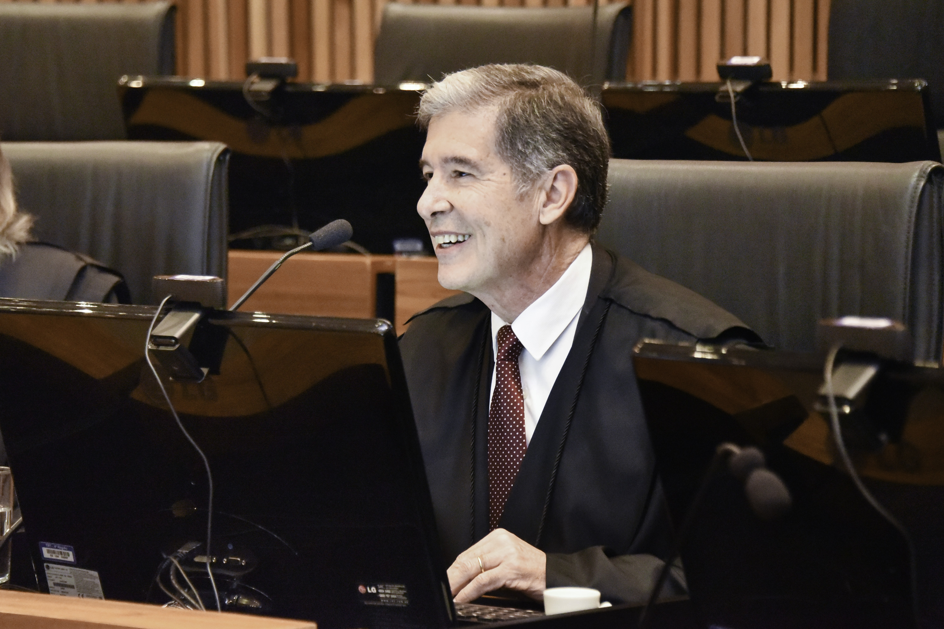 Roberto Zonta é branco e grisalho. Usa cabelo curto, veste toga sobre terno e gravata. Ele em sua mesa na nave do Plenário. Está sorrindo e olhando para a esquerda.