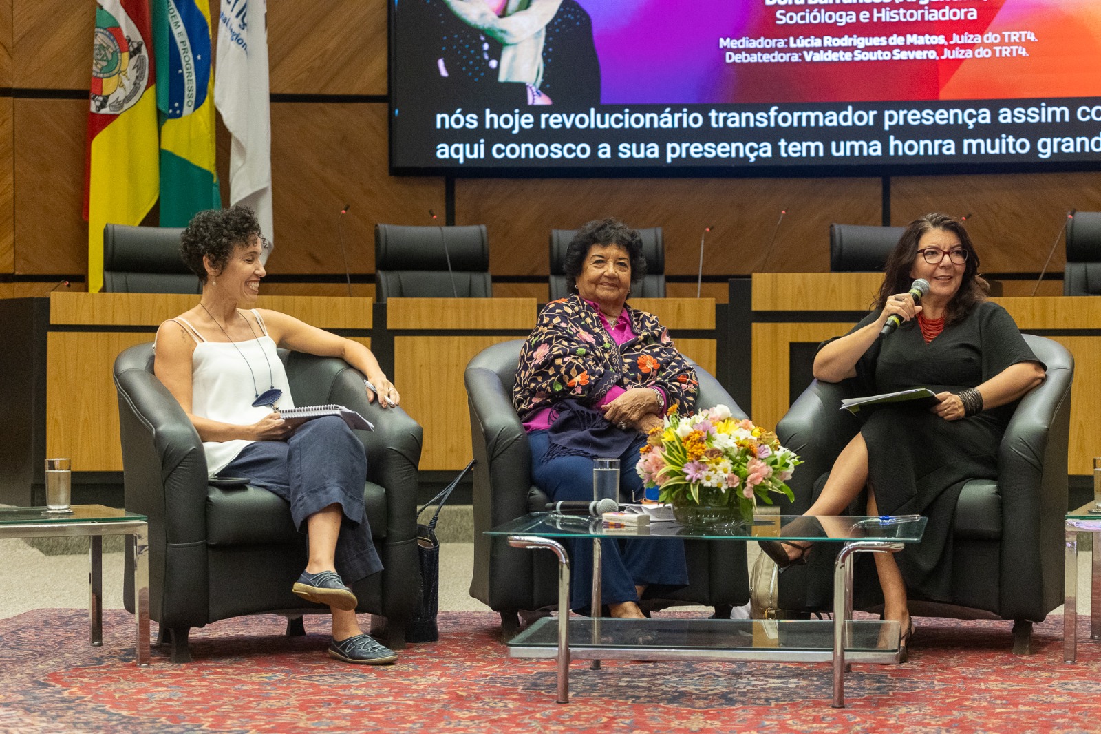 A foto mostra a juiza lucia falando.