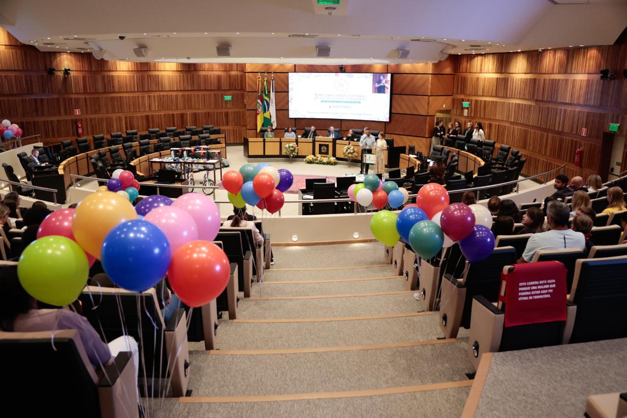 Cerimônia de premiação de 2025. Foto em ângulo aberto, do plenário. Aparecem balões coloridos amarrados nas poltronas do plenário, como decoração.