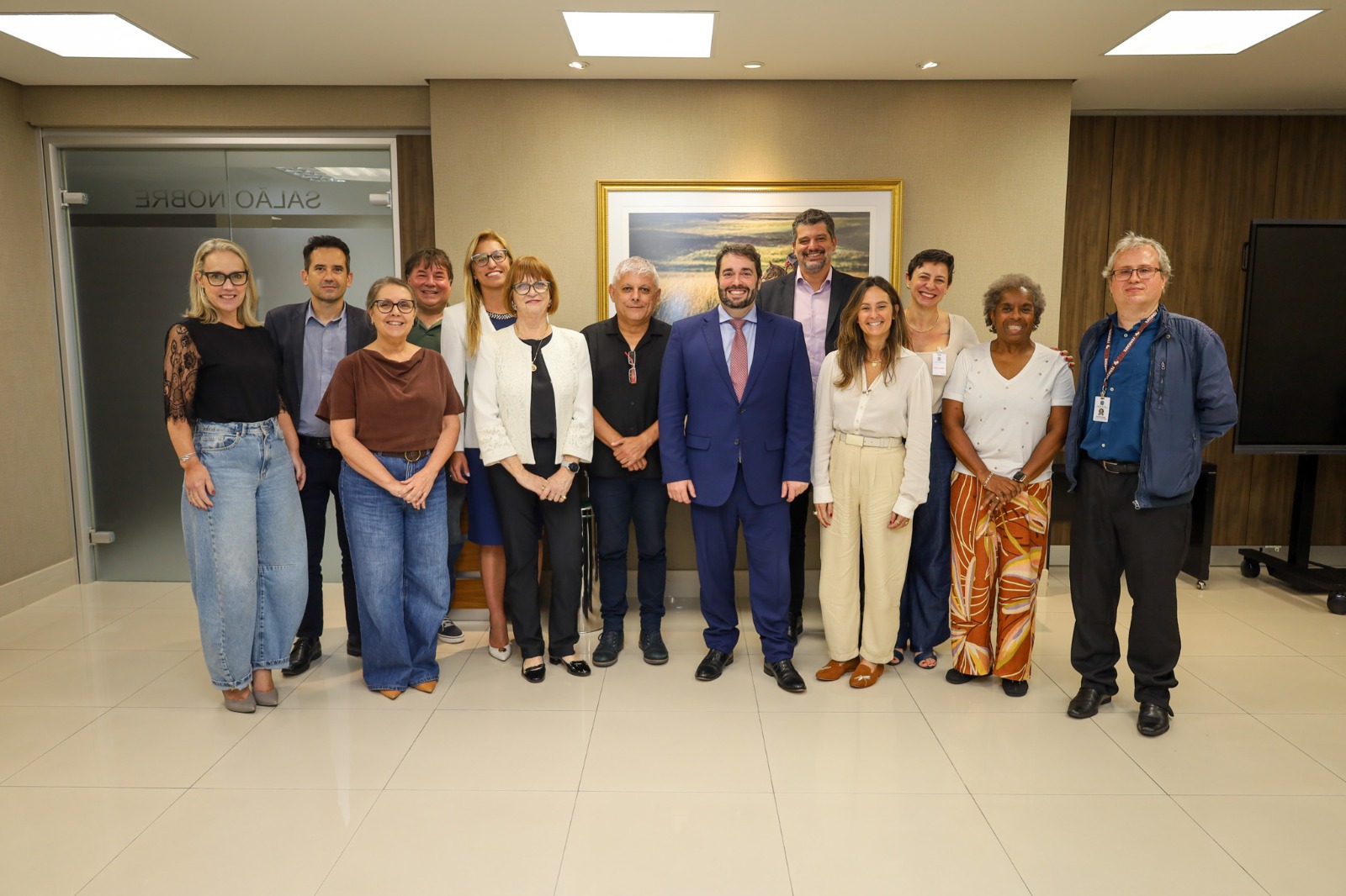 A foto mostra uma reunião ao redor de uma mesa.