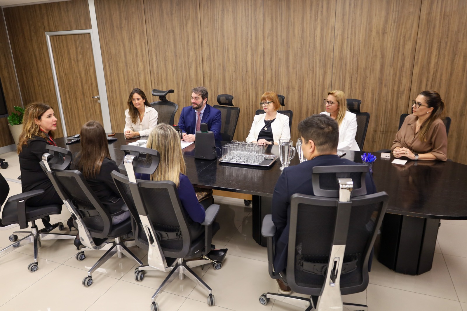 A foto mostra uma reunião ao redor de uma mesa.