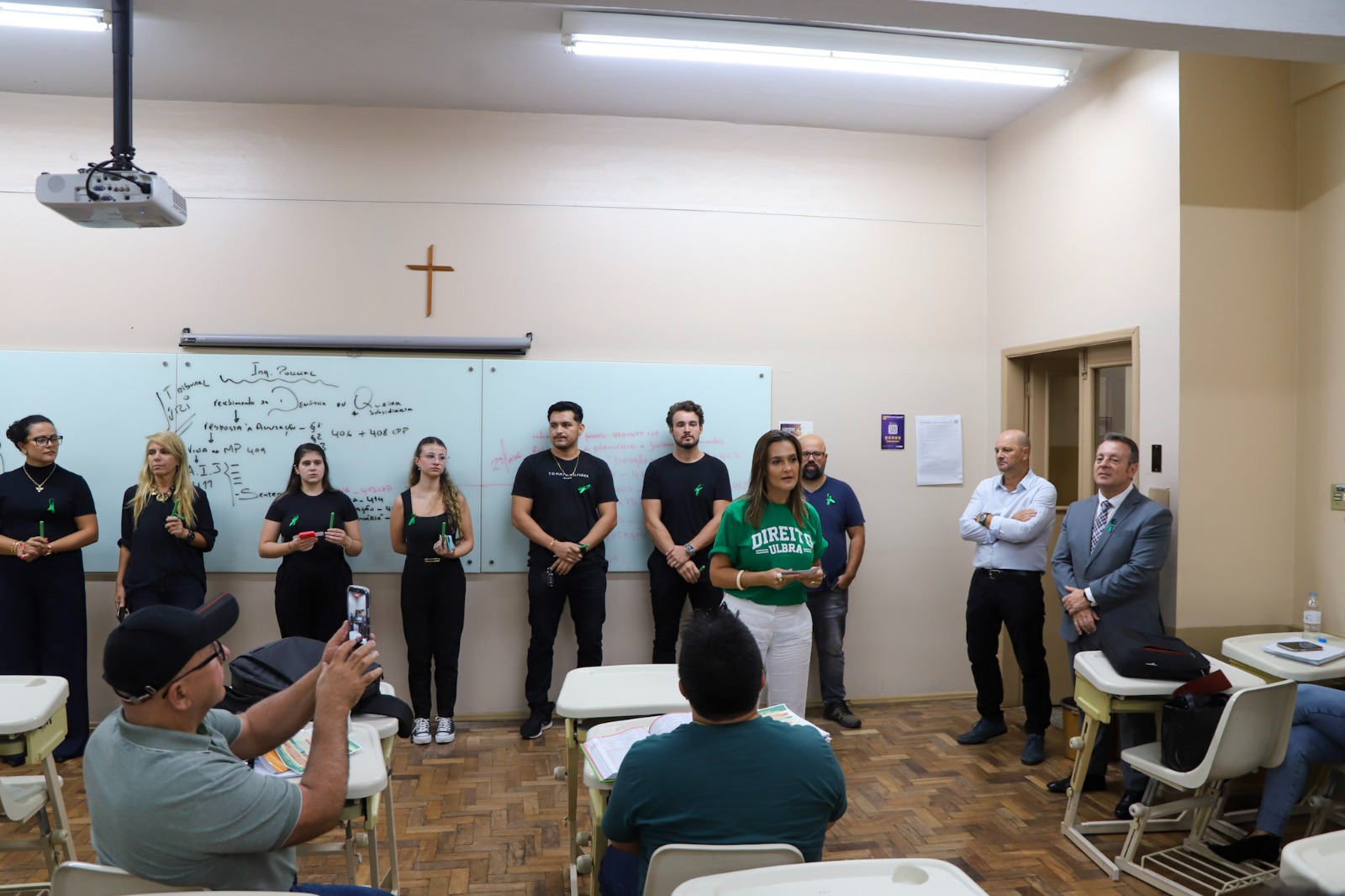 Professora e márcio de fundo falando com alunos