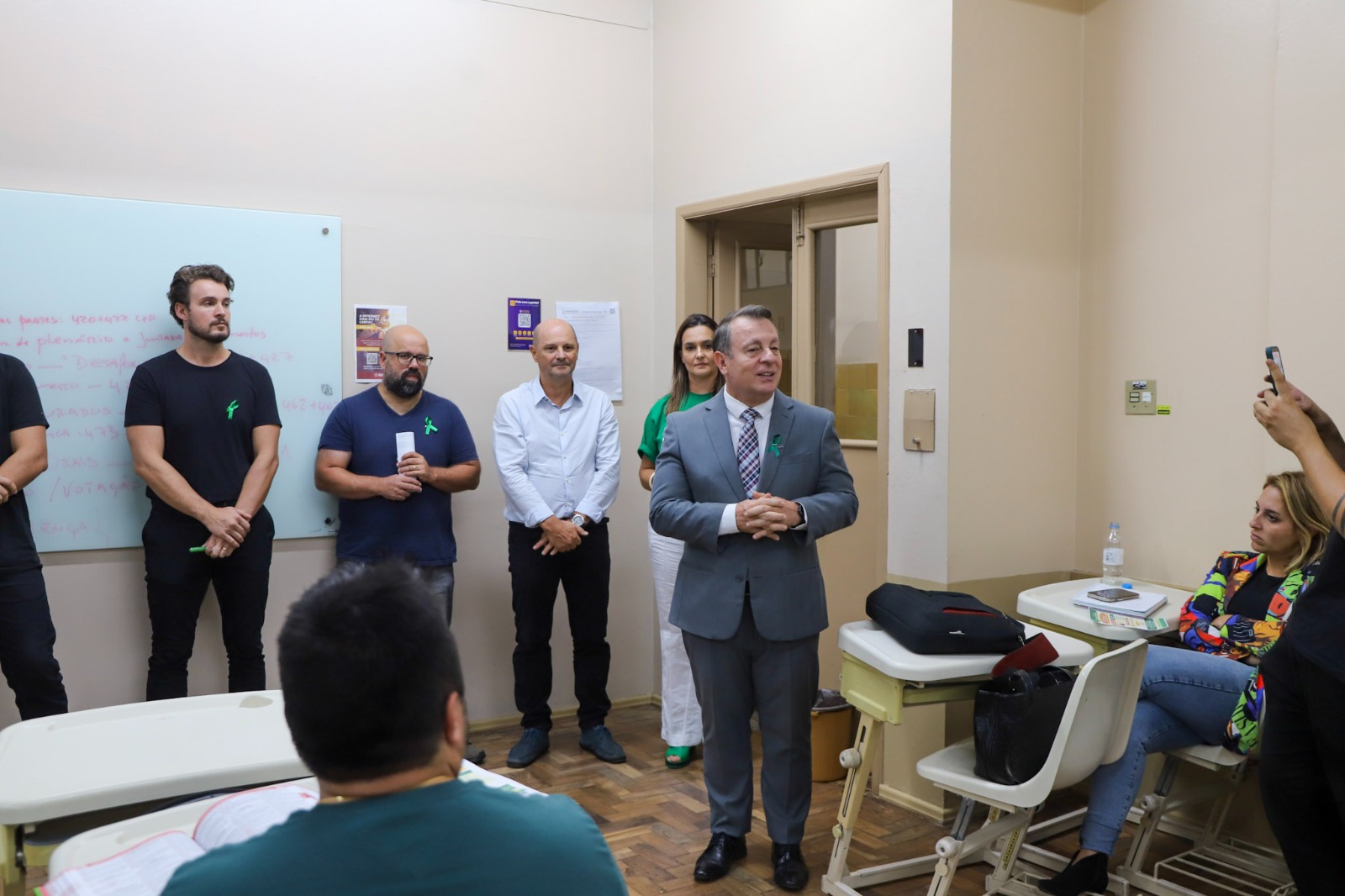 márcio com alguns aluno na frente ouvindo sua palestra.