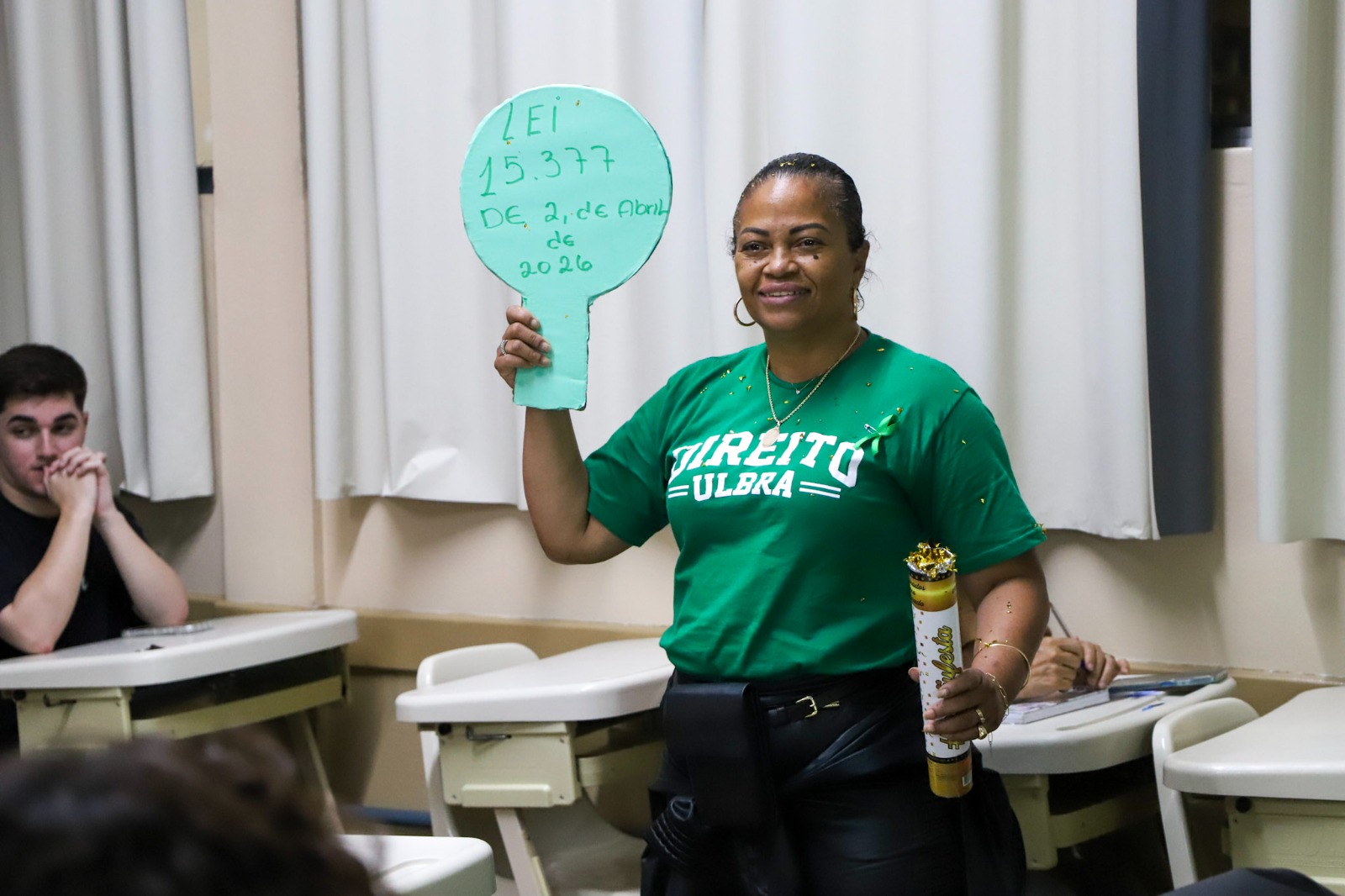 Aluna com cartaz em mãos.