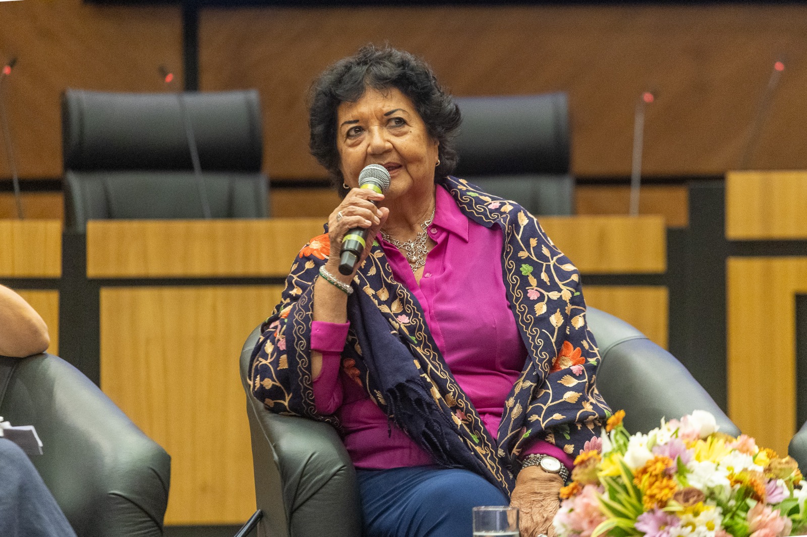 A foto mostra a historiadora Dora falando.