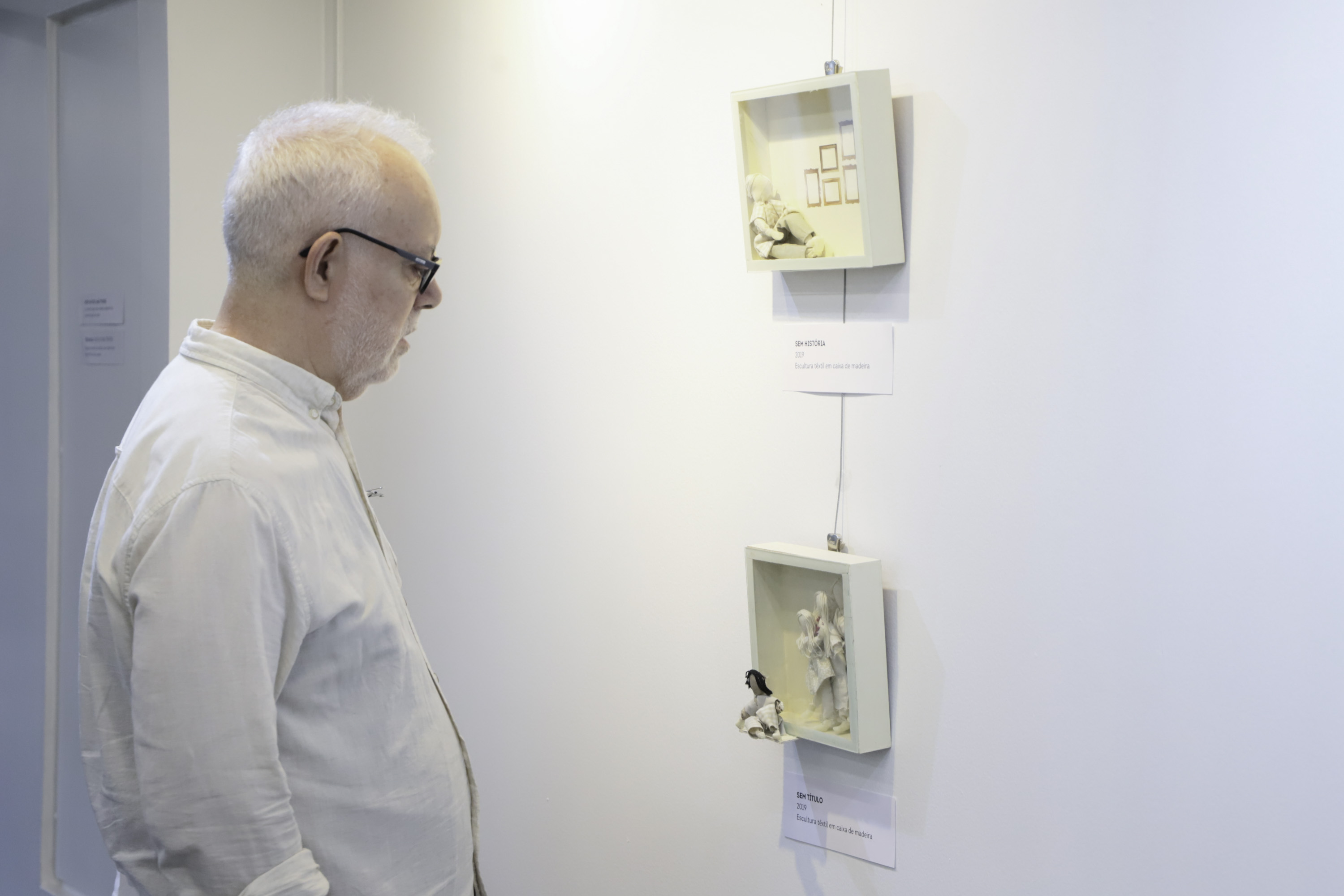 homem observa quadros