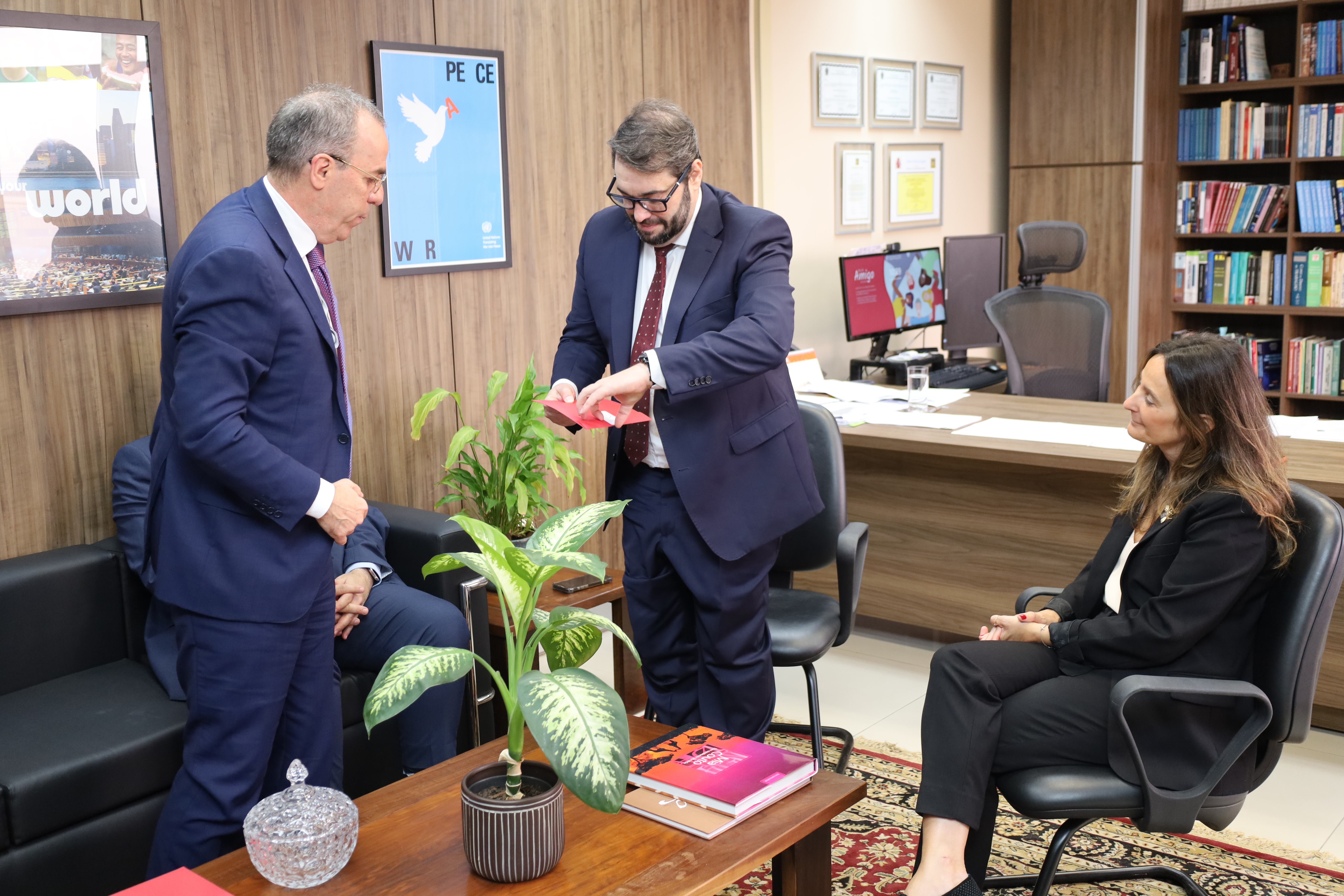 A imagem mostra o presidente do TRT/RS, em pé, recebendo o convite das mãos de Luiz Henrique Cabanellos Schuh.