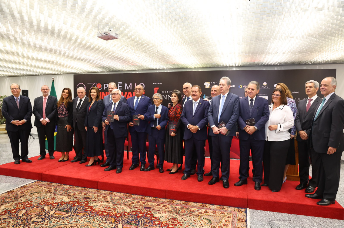 A imagem mostra convidados na cerimônia de lançamento do prêmio, em pé, lado a lado.