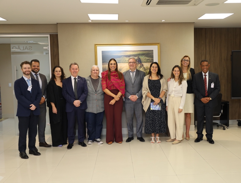 A fotografia mostra os onze participantes da reunião, lado a lado, em pé, posando para a foto.