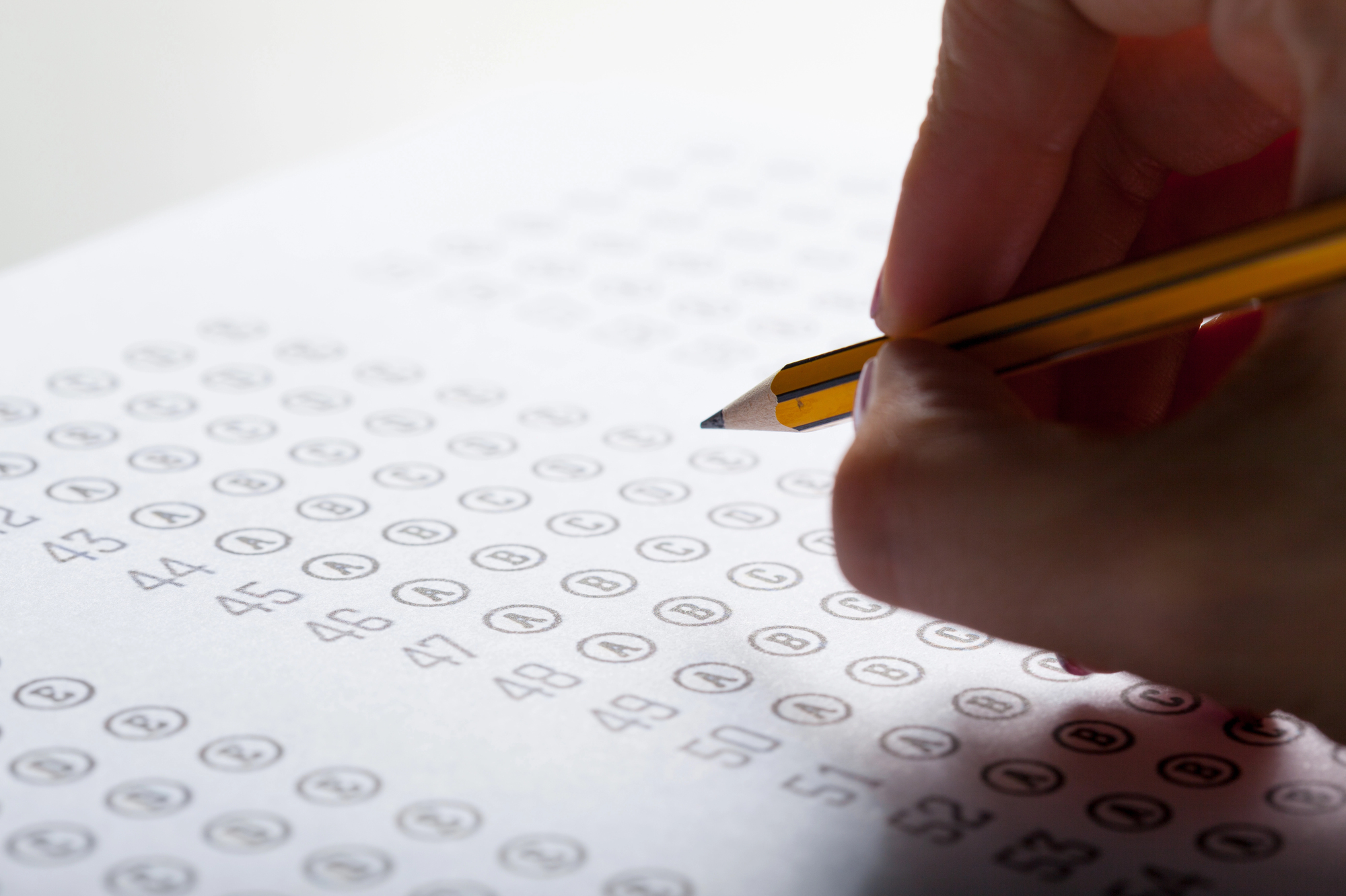 foto de uma mulher preenchendo uma folha de respostas de uma prova.