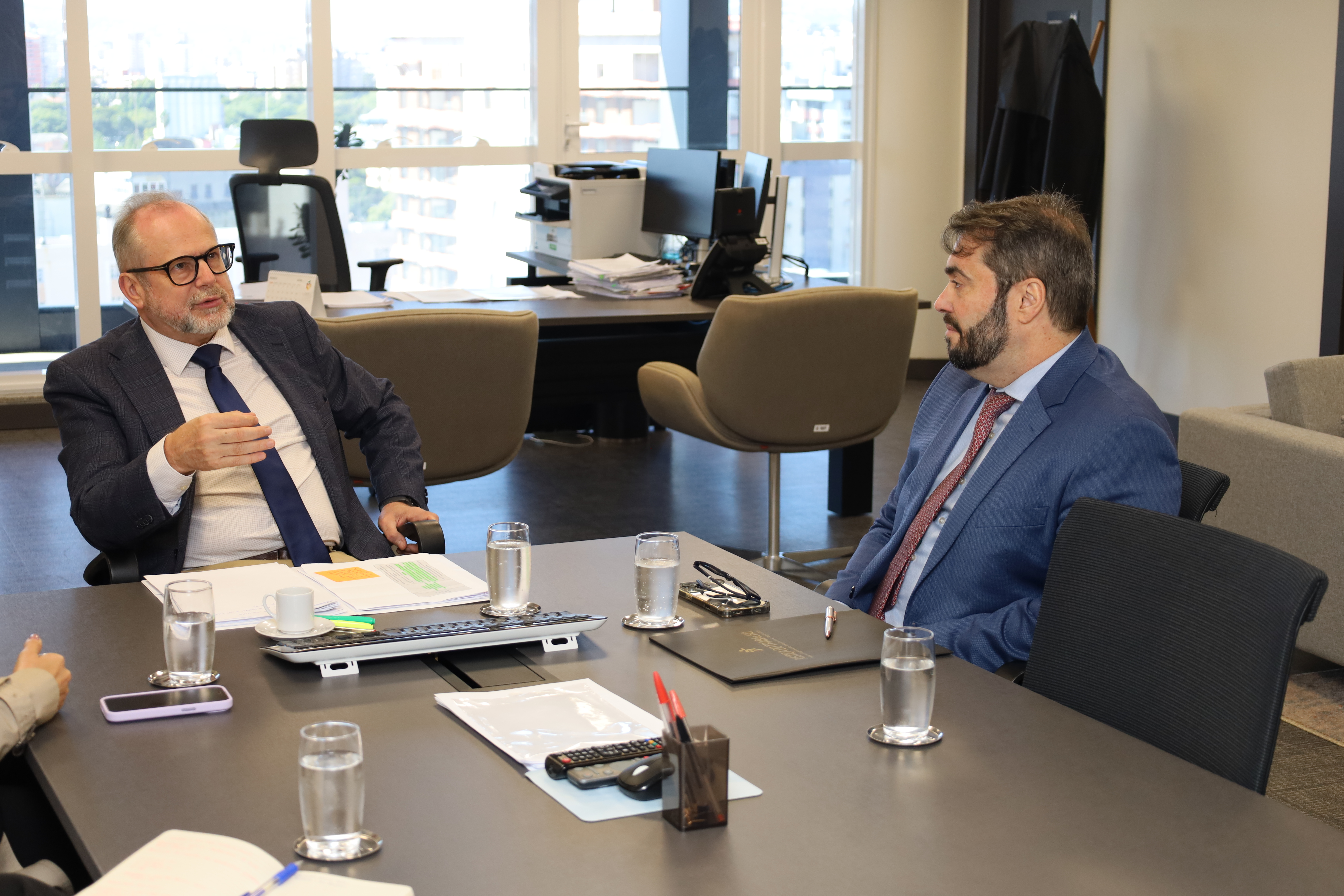 A fotografia mostra, sentados à mesa de reuniões, conversando, o desembargador Cláudio Luís Martinewski e o presidente do TRT-RS, desembargador Alexandre Corrêa da Cruz.