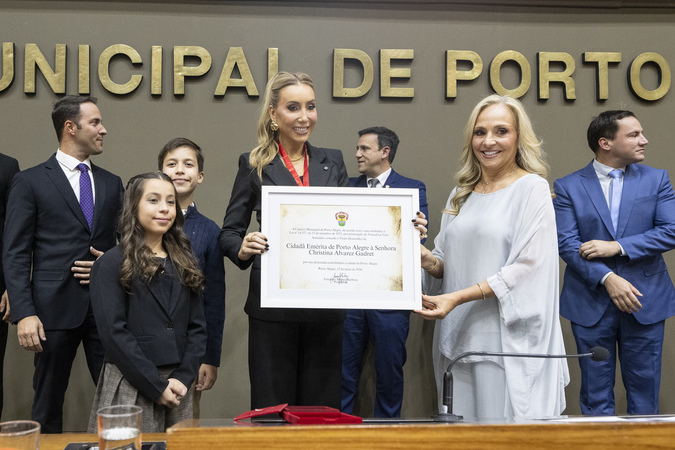 Christina Alvarez Gadret segurando o Título de Cidadã, do lado da vereadora Vera Armando.