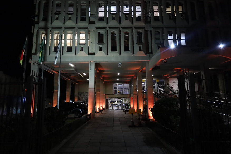 Fachada do Foro Trabalhista de Porto Alegre com iluminação laranja.