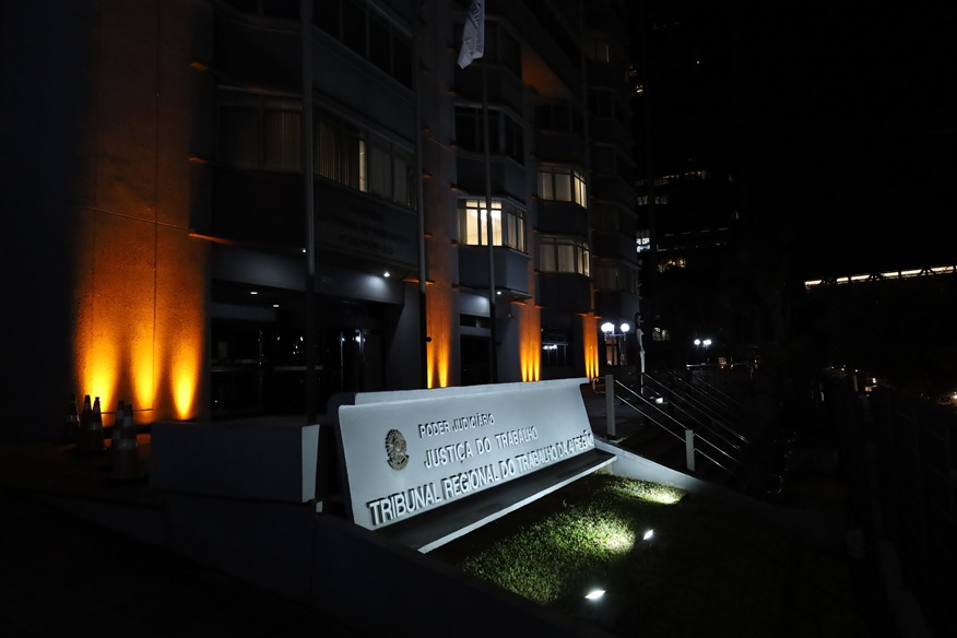 Fachada do TRT-RS com iluminação laranja.