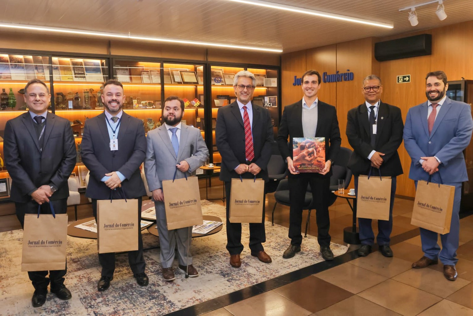 A foto mostra sete pessoas lado a lado posando para foto.