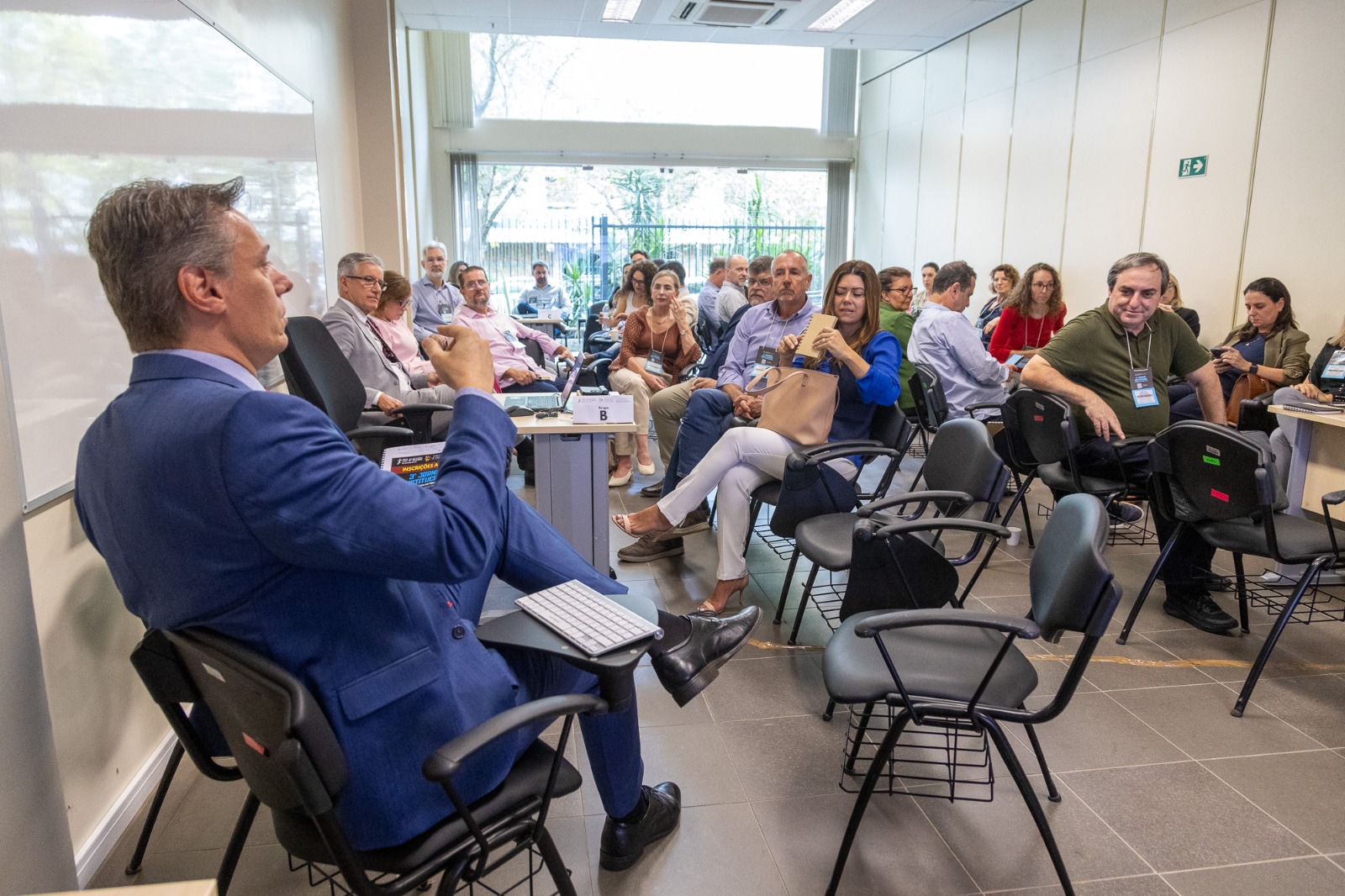 A foto mostra o juiz Fábio palestrando com magistrados sentados a frente.Fábio.jpg