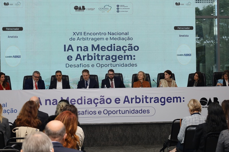 A fotografia mostra a mesa de abertura, a distância, todos sentados.