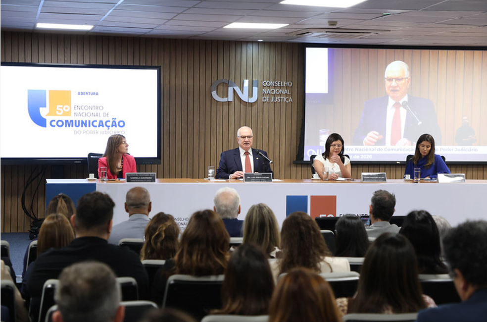 Foto do Encontro Comunicação com plano aberto da mesa oficial e público presente